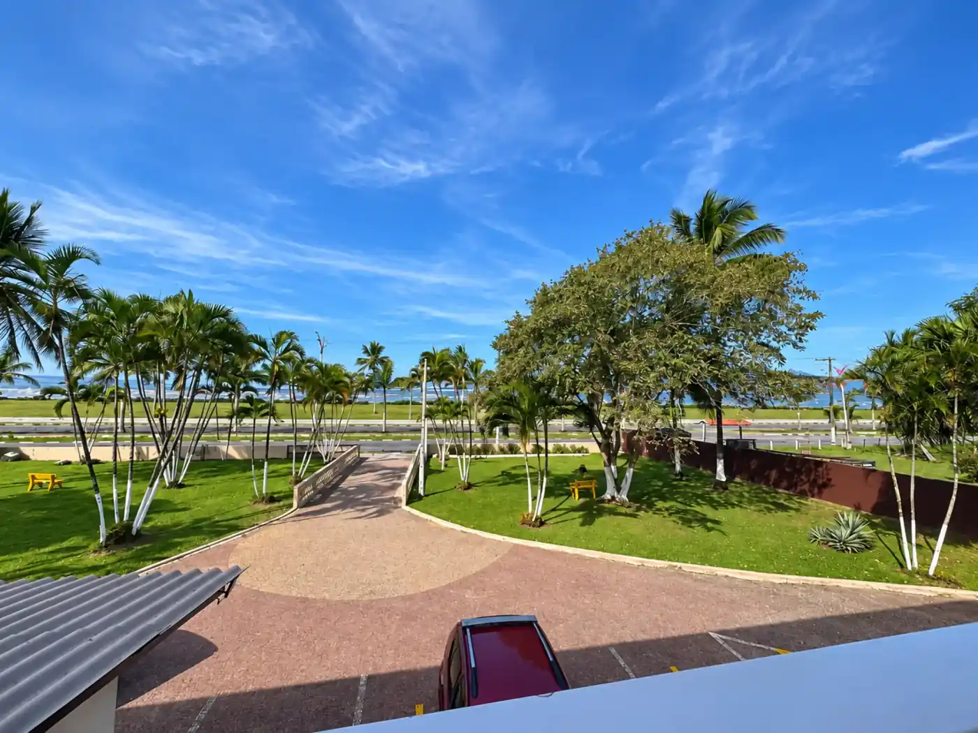 Área do hotel com palmeiras e o litoral de Caraguatatuba ao fundo